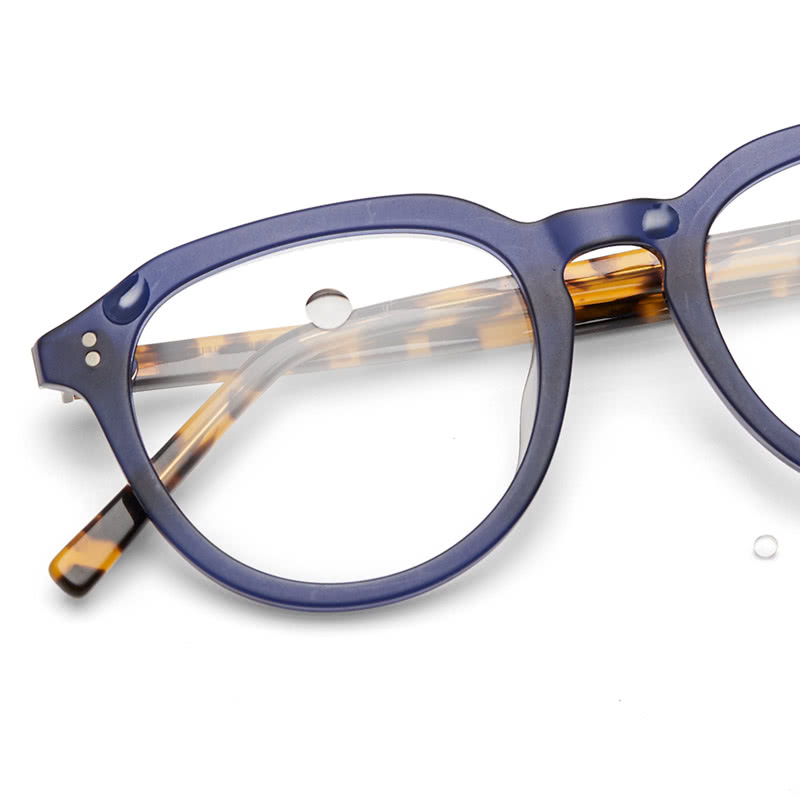 Navy blue tortoiseshell eyeglass frames with round lenses and distinctive bridge design.