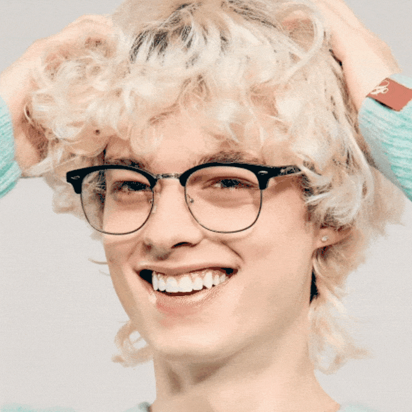 Person smiling, wearing black-rimmed eyeglasses.