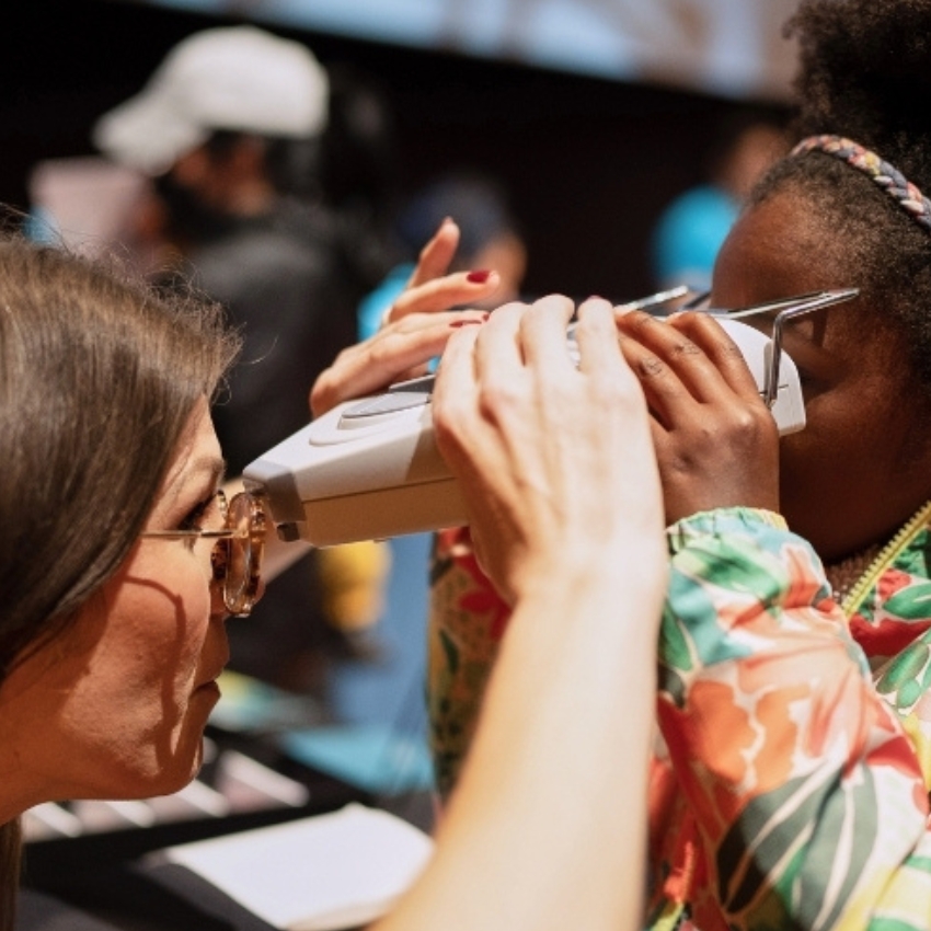 Woman using a handheld vision testing device.